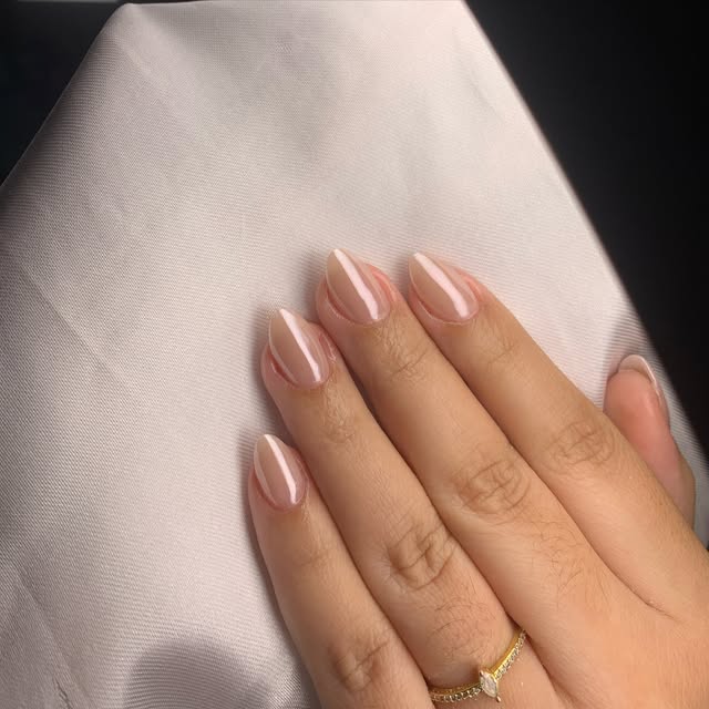 Unhas em tom rosado com detalhe branco