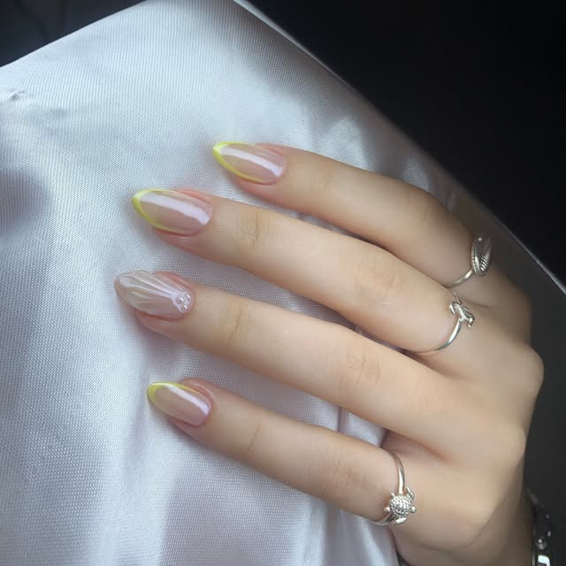 Unhas decoradas em tons claros e amarelo